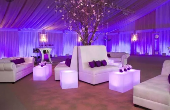 Purple-lit lounge furniture and cherry blossom centerpieces