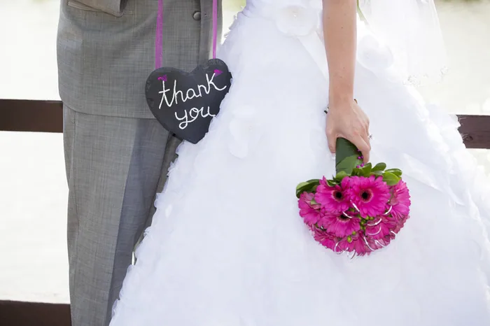 Bride holding a bouquet with a thank-you sign